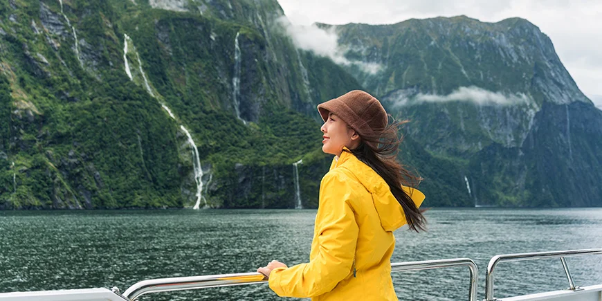 Kvinde sejler i Milford Sound i New Zealand