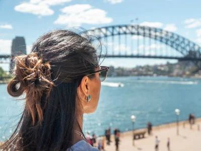 Kvinde kigger på Sydney Harbour Bridge i Sydney, Australien