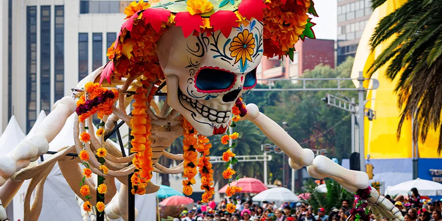 Stort skelet, der er pyntet med blomster ifm. parade på de dødes dag i Mexico City