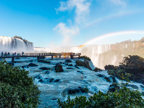 Gangbro på den argentinske side af Iguazú Falls på en solrig dag