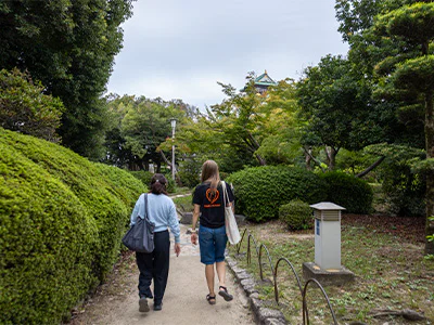 Japansk guide går med TourCompass-medarbejder ved Osaka Castle i Japan