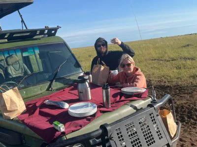 To personer spiser morgenmad på safaribilen