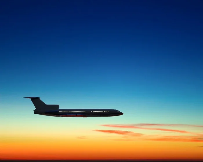 Fly på himmel med solnedgang