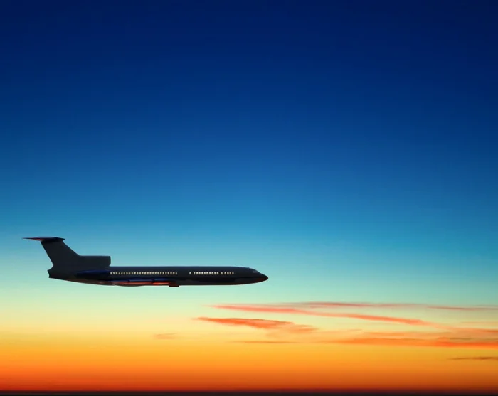 Fly på himmel med solnedgang