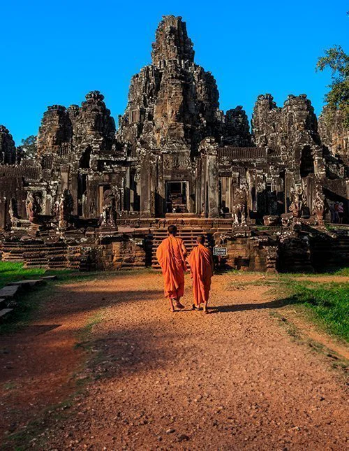 Munkene blandt Bayon-templets ældgamle stenansigter, Angkor, Cambodja