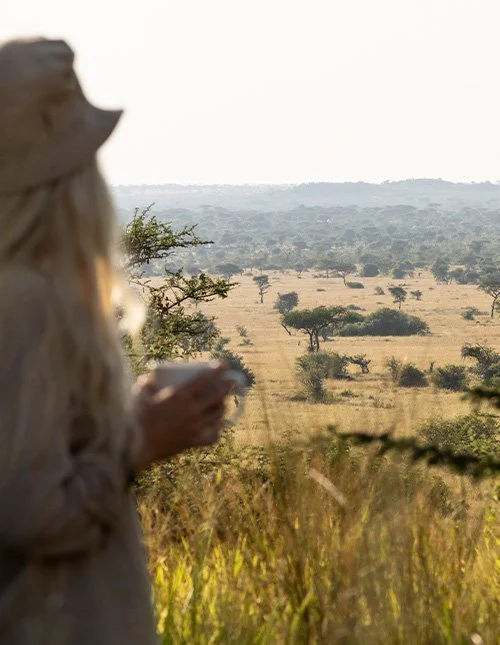 Kvinde kigger ud over savannelandskab
