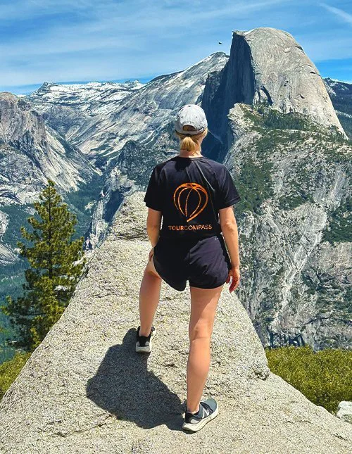 Person med TourCompass t-shirt nyder udsigt over bjerge i USA