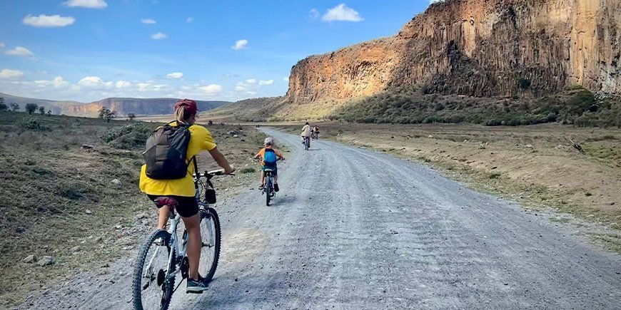 Kvinde og familie cykler i Hells Gate Nationalpark i Kenya.