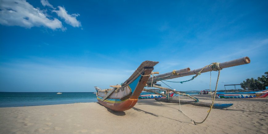 Båd på strand i Trincomalee i Sri Lanka