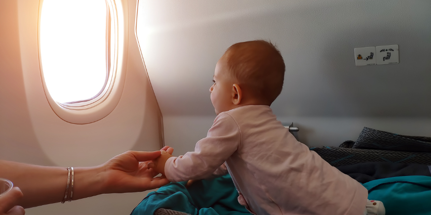 Lille baby kigger ud ad flyvinduet