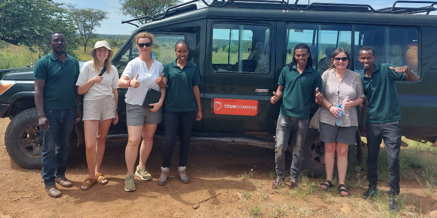 Safarirejsende og guider ved safaribilen i Afrika