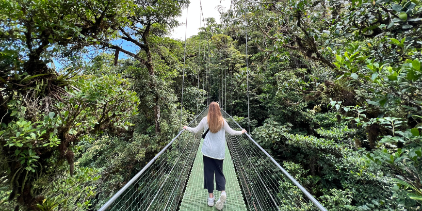 Kvinde stående på hængende broer i monteverde