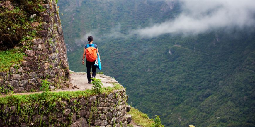 Kvinder går på kanten af en klippe, Machu Picchu, Peru