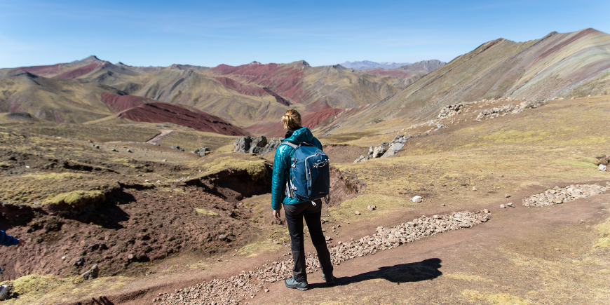 Kvinde vandrer ved Rainbow Mountain i Peru