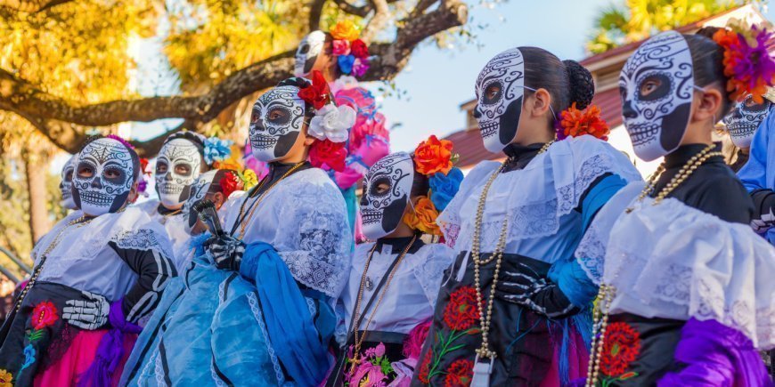 Kvinder i farverige kostumer med dekorerede kranier til De Dødes Dag i Mexico