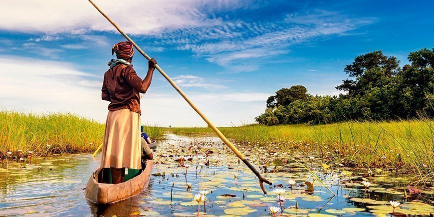 Kvinde sejler i båd i Okavango-deltaet i Botswana