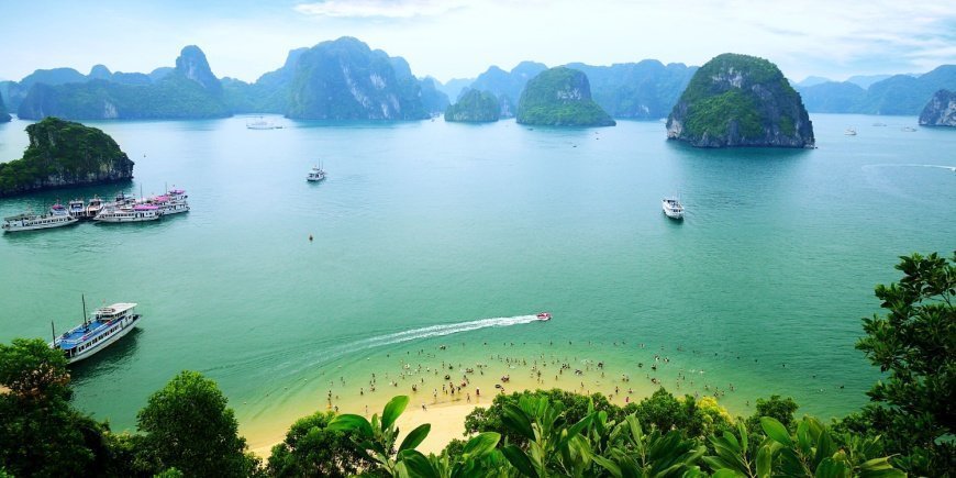 Mennesker bader fra strand i Ha Long bugten