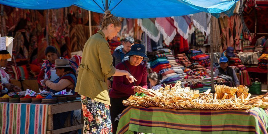 Kvinde køber lokale souvenirs i Cusco i Peru