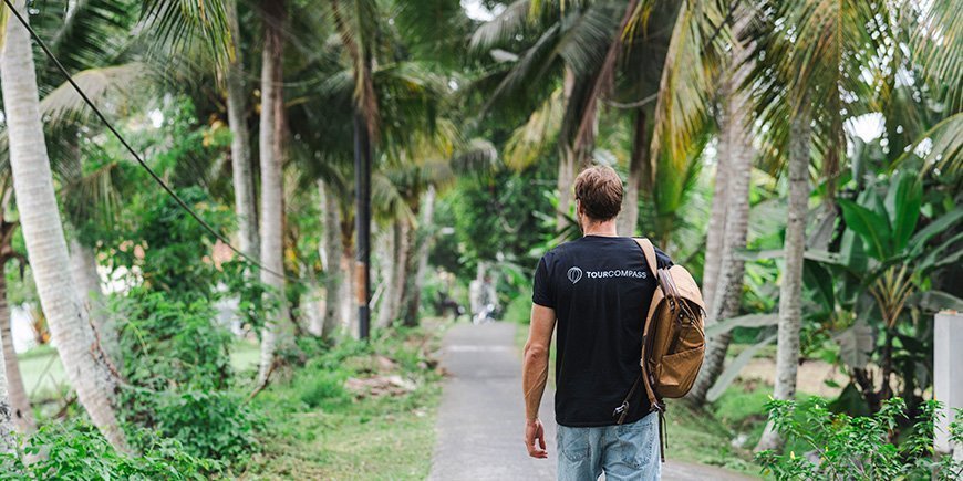 Mand går under palmetræer på Bali i Indonesien