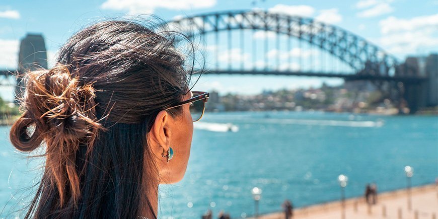Kvinde kigger på Sydney Harbour Bridge i Sydney, Australien