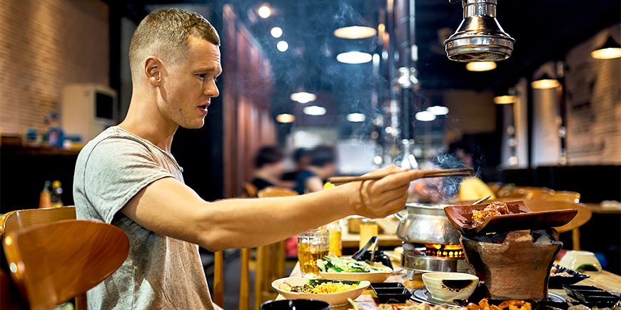 Mand spiser med pinde på restaurant i Vietnam