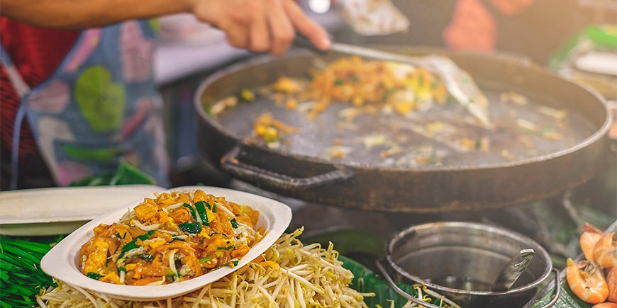 Kvinde laver Pad Thai på marked i Bangkok