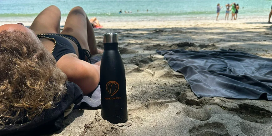 Kvinde ligger i sandet en solrig dag på strand i Costa Rica.