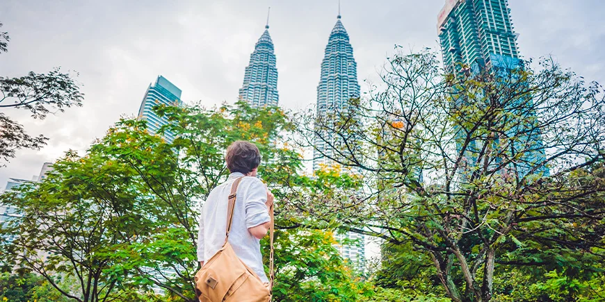 Mand kigger på Petronas Twin Towes i Kuala Lumpur i Malaysia