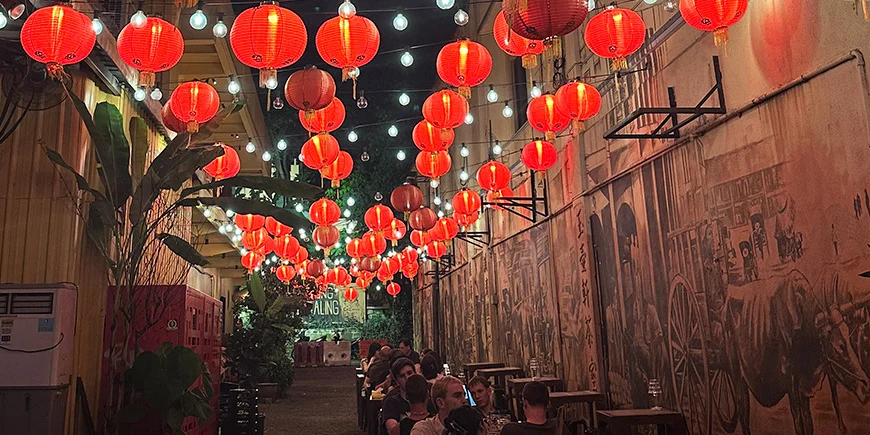 Røde lanterner og spisende mennesker på Kwai Chai Hong i Chinatown, Kuala Lumpur