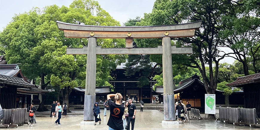 Kvinde tager billede af par under en Tori-port ved Meiji Shrine