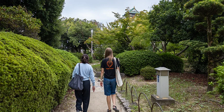 Japansk guide går med TourCompass-medarbejder ved Osaka Castle i Japan