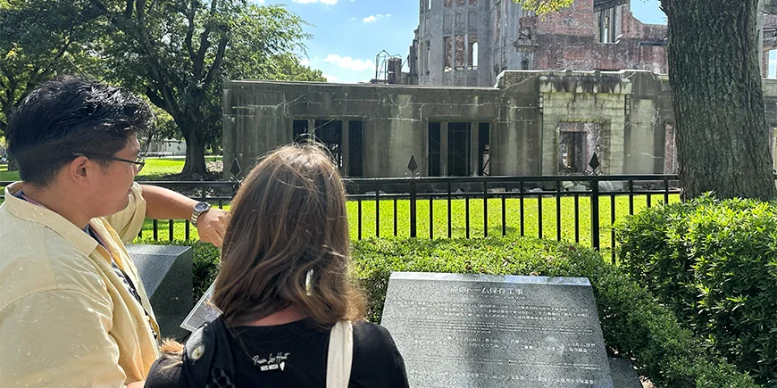 Mandlig japansk guide med kvindelig turist i Hiroshima i Japan