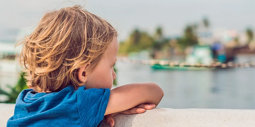 Dreng kigger på både i vandet ved Phu Quoc i Vietnam