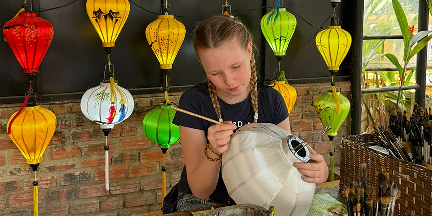 Pige maler på lanterner i Hoi An i Vietnam