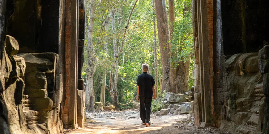 Mand går gennem ruinerne i Cambodia