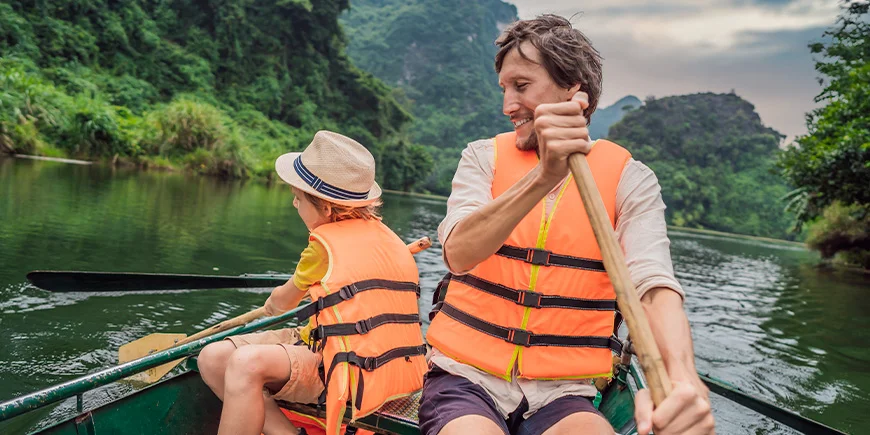 Far og søn sejler ved Ninh Binh i Vietnam