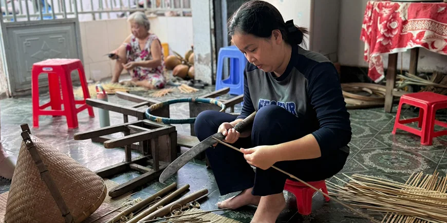 Vietnamesisk kvinder laver ting ud af kokos