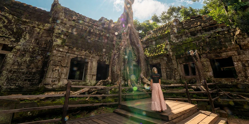 Kvinde i TourCompass-tshirt står i Angkor i Cambodia