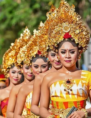 Gruppe af balinesiske mennesker. Smukke danserinder i traditionelle dragter danser på gadeparade ved kunst- og kulturfestival.